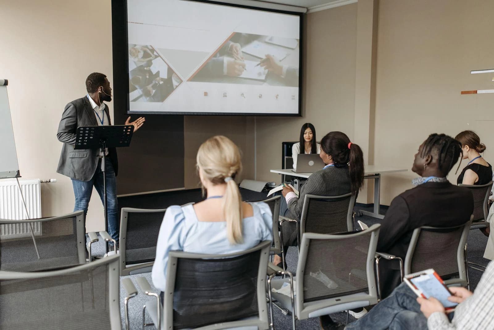 Webseite für Bildungsinstitute: Dozent präsentiert vor Teilnehmenden in einem Seminarraum