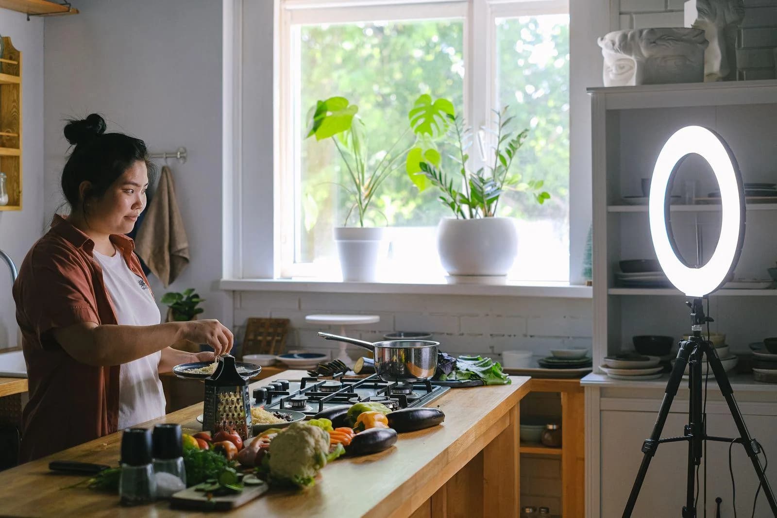 Webseite für Creator und Influencer: Creatorin filmt sich beim Kochen mit Ringlicht in der Küche