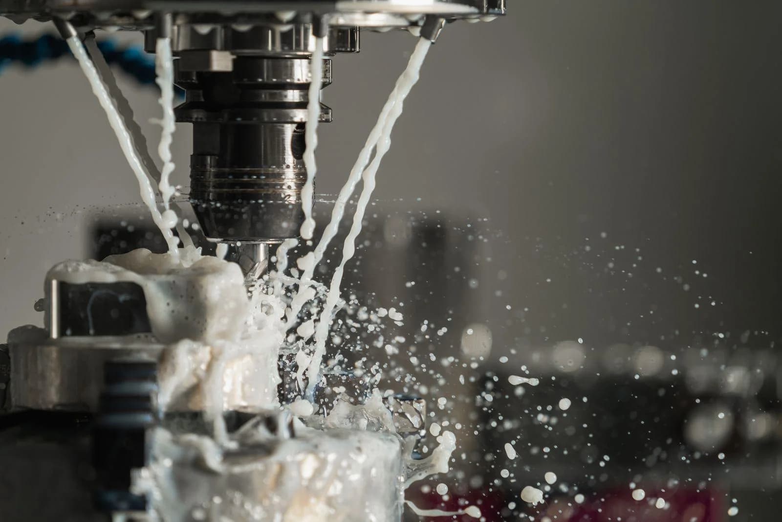 Webseite für Industrie und Produktion: CNC-Fräse bei der Metallbearbeitung mit Kühlmittel