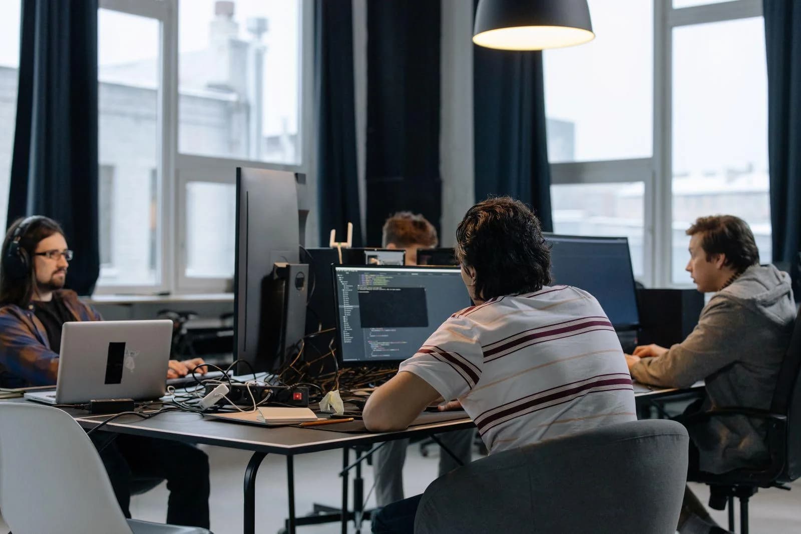 Webseite für IT- und Softwareunternehmen: Entwicklerteam arbeitet an Rechnern im Großraumbüro
