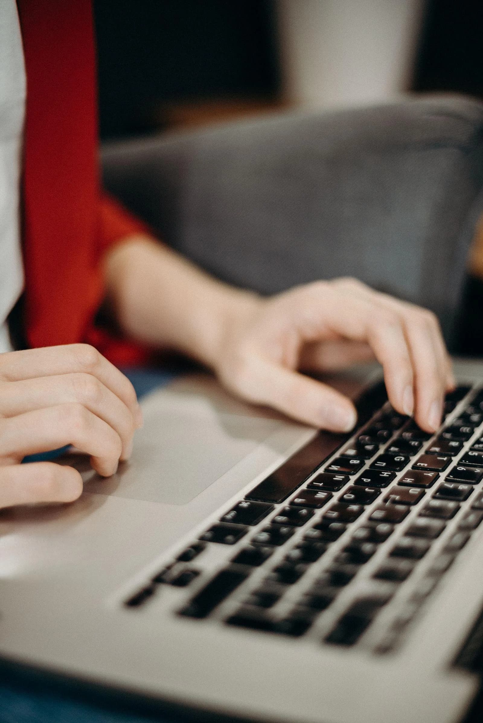 Webdesign für Unternehmen: Hände auf der Tastatur eines Laptops beim Umsetzen eines Entwurfs