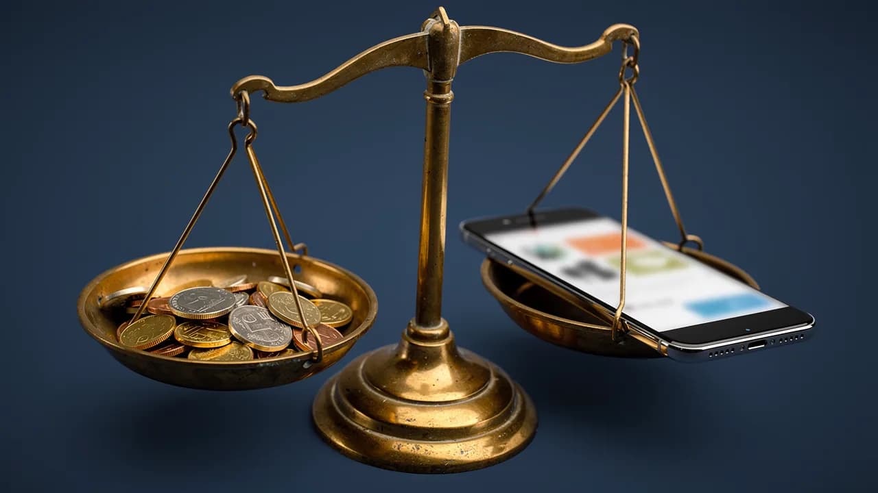 Beste und günstigste Website im Vergleich: Waage mit Münzen auf der einen und einem Smartphone mit Firmenseite auf der anderen Seite